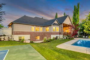 Expansive backyard featuring a rectangular swimming pool, concrete patio, and a painted sports court