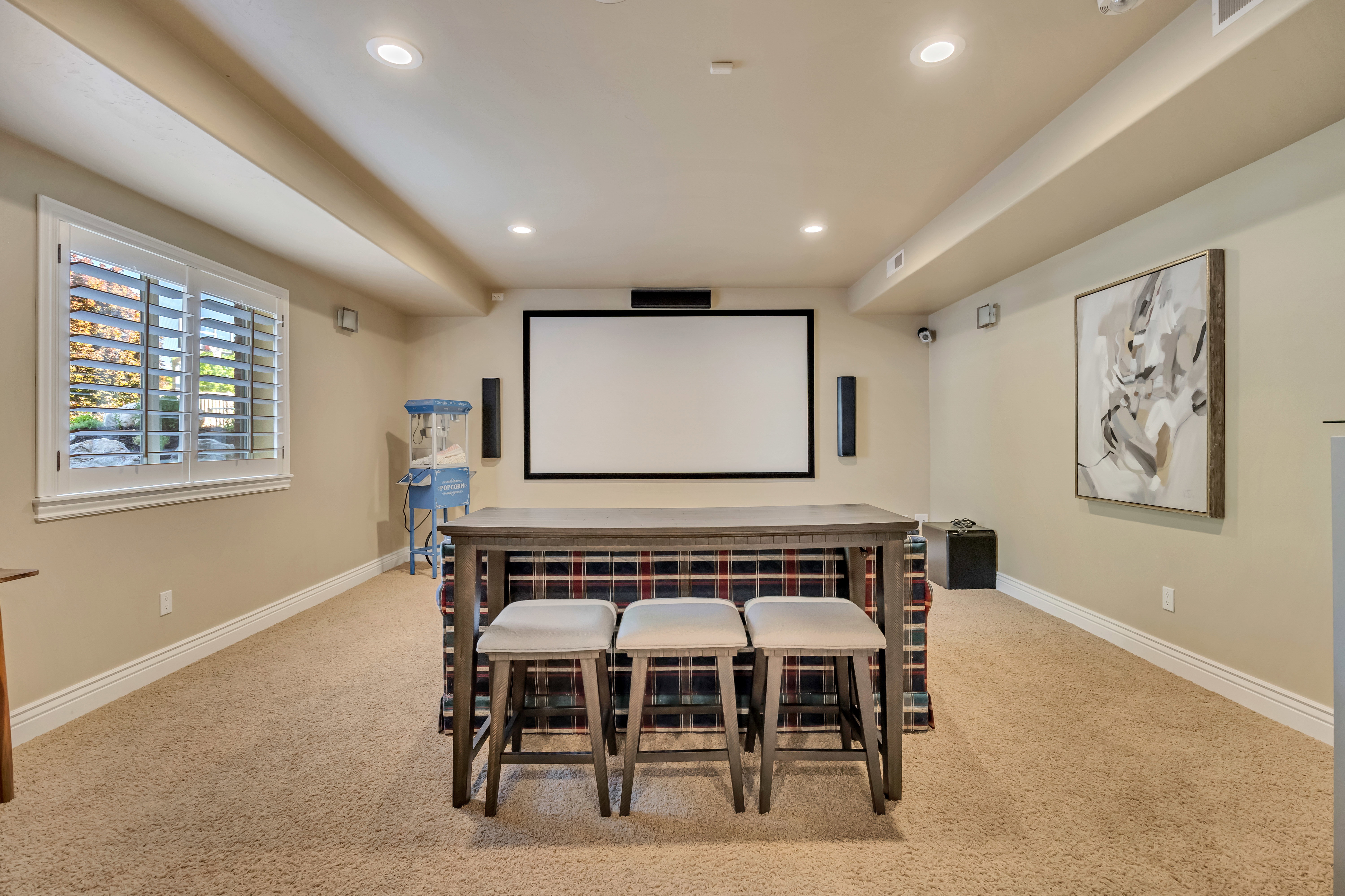 Media room featuring a projector screen, integrated audio speakers, recessed lighting, and carpet flooring