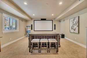 Media room featuring a projector screen, integrated audio speakers, recessed lighting, and carpet flooring