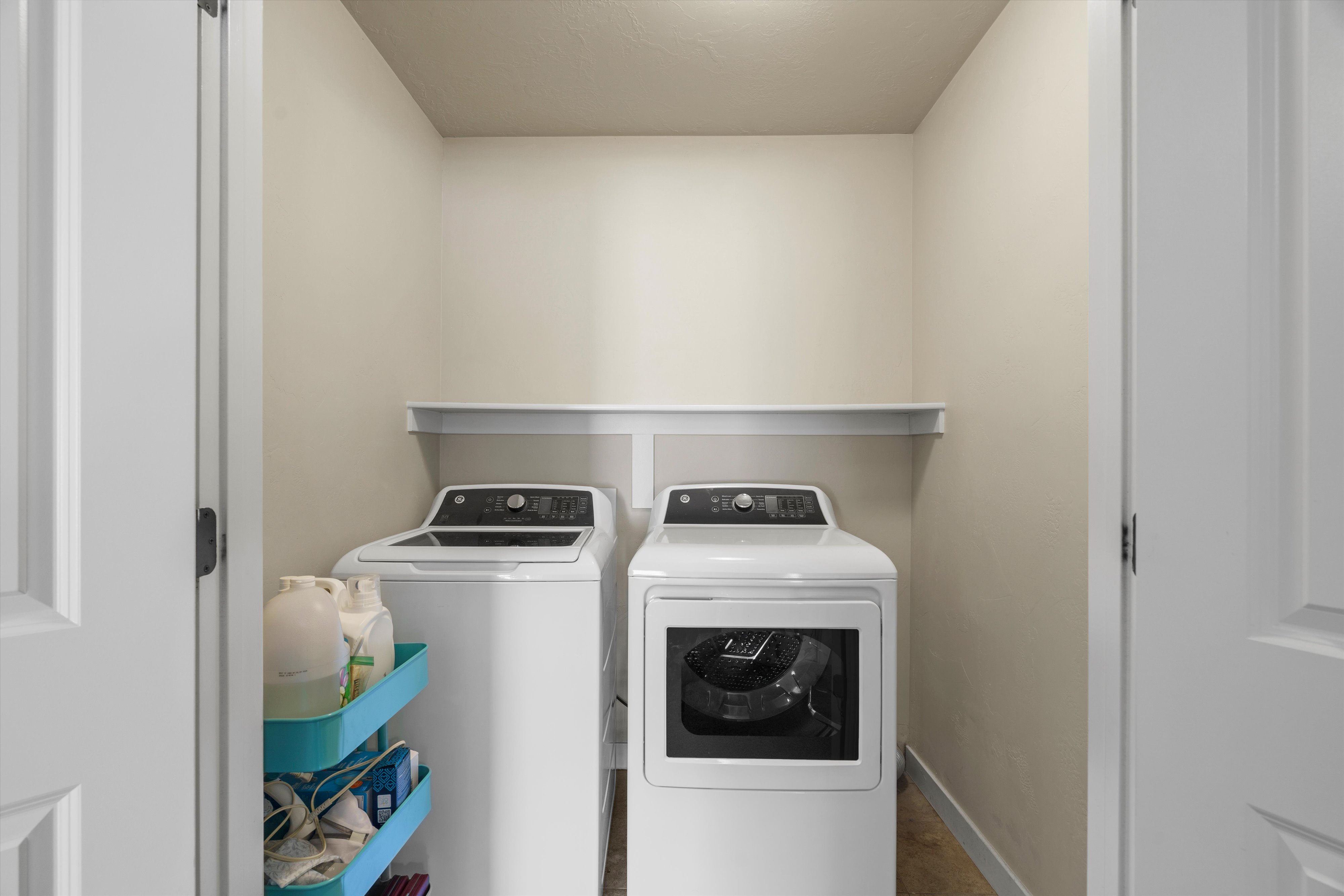 Dedicated laundry area featuring a built-in white shelf and neutral wall tones
