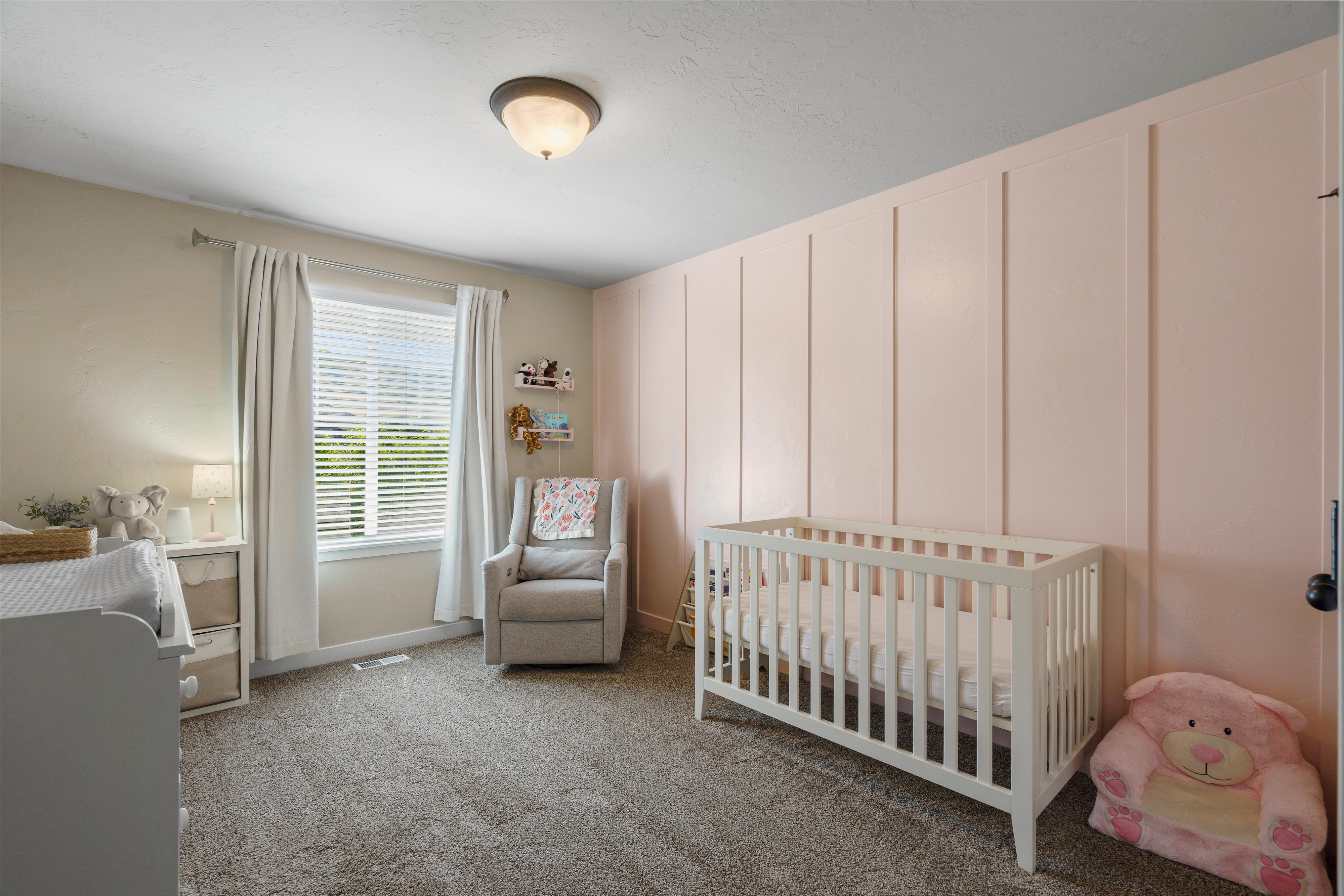 Room featuring a decorative accent wall with vertical paneling, neutral wall paint, a window with blinds, and carpeted flooring