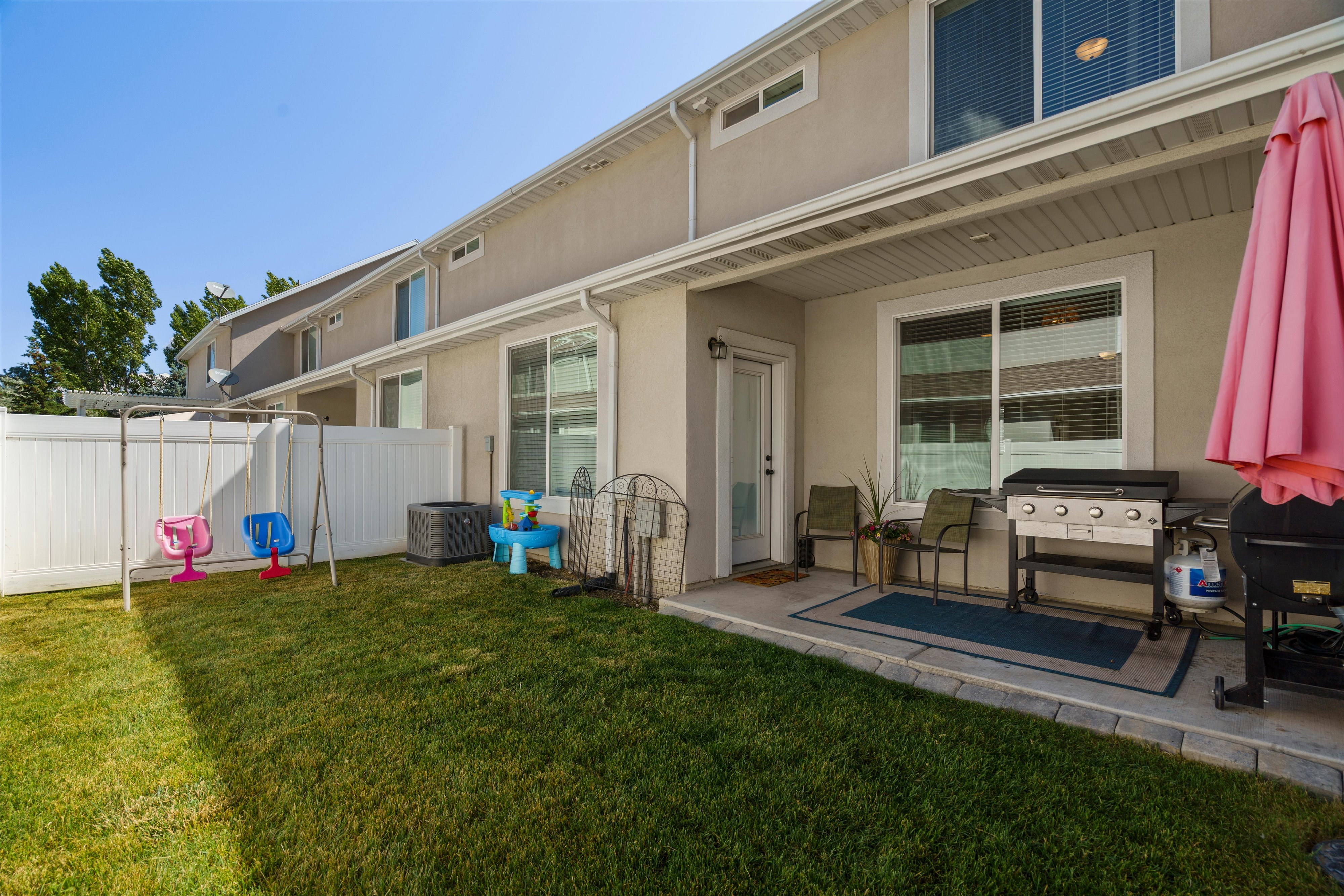 Manicured green lawn with a white privacy fence