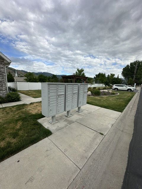 Community mailbox cluster with concrete pad, bordering a paved street