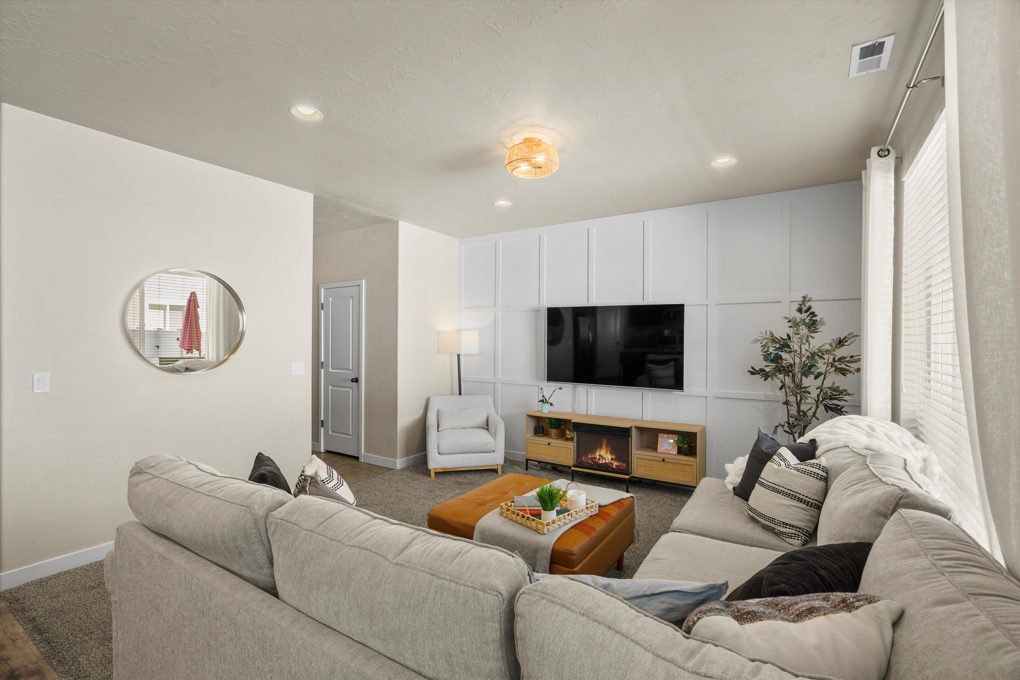 Living area featuring a wainscoted accent wall, recessed lighting, and a modern ceiling fixture