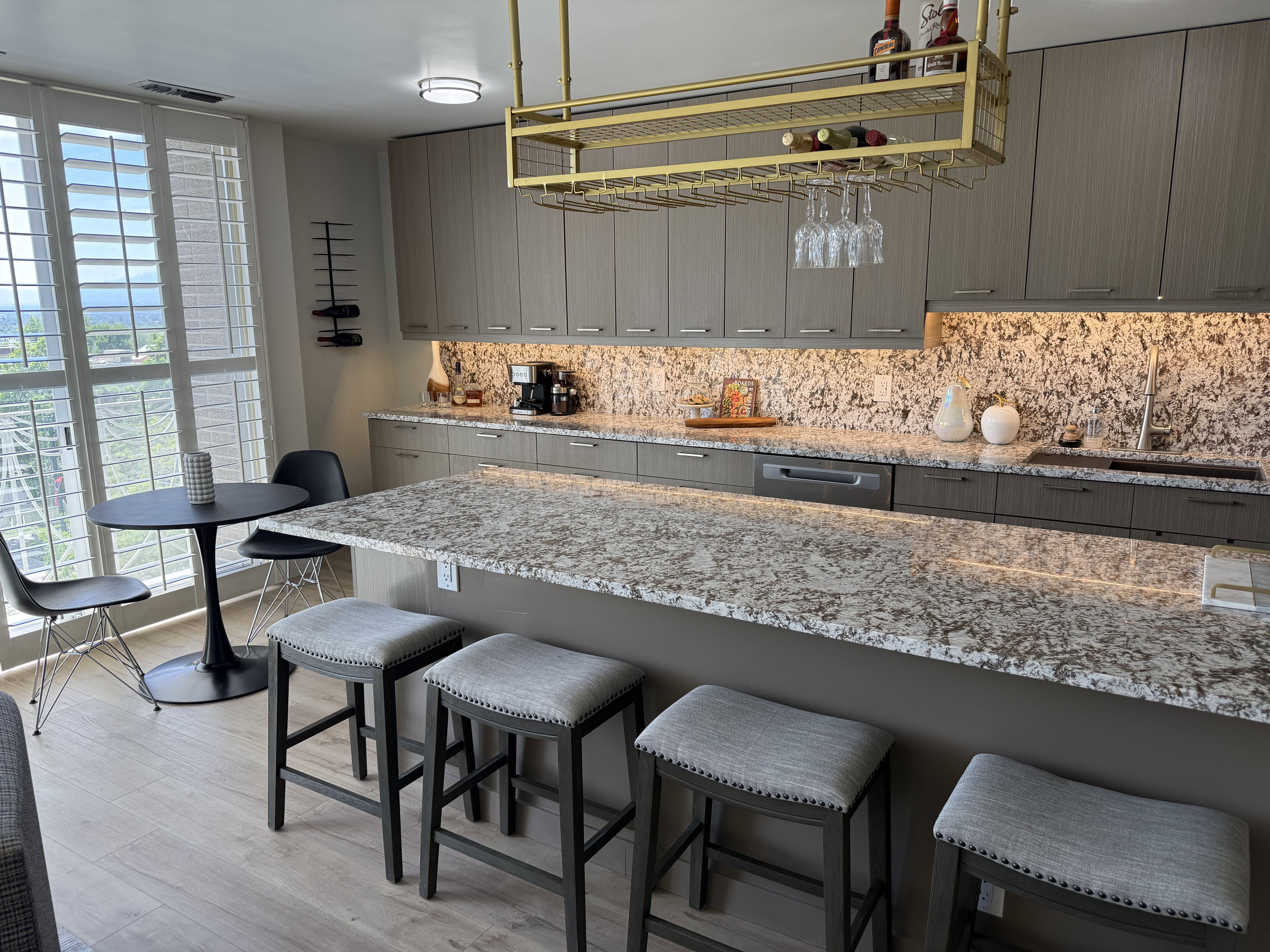 Contemporary kitchen featuring light wood-finish flooring, an oversized island with a light-toned countertop, and a built-in cooktop