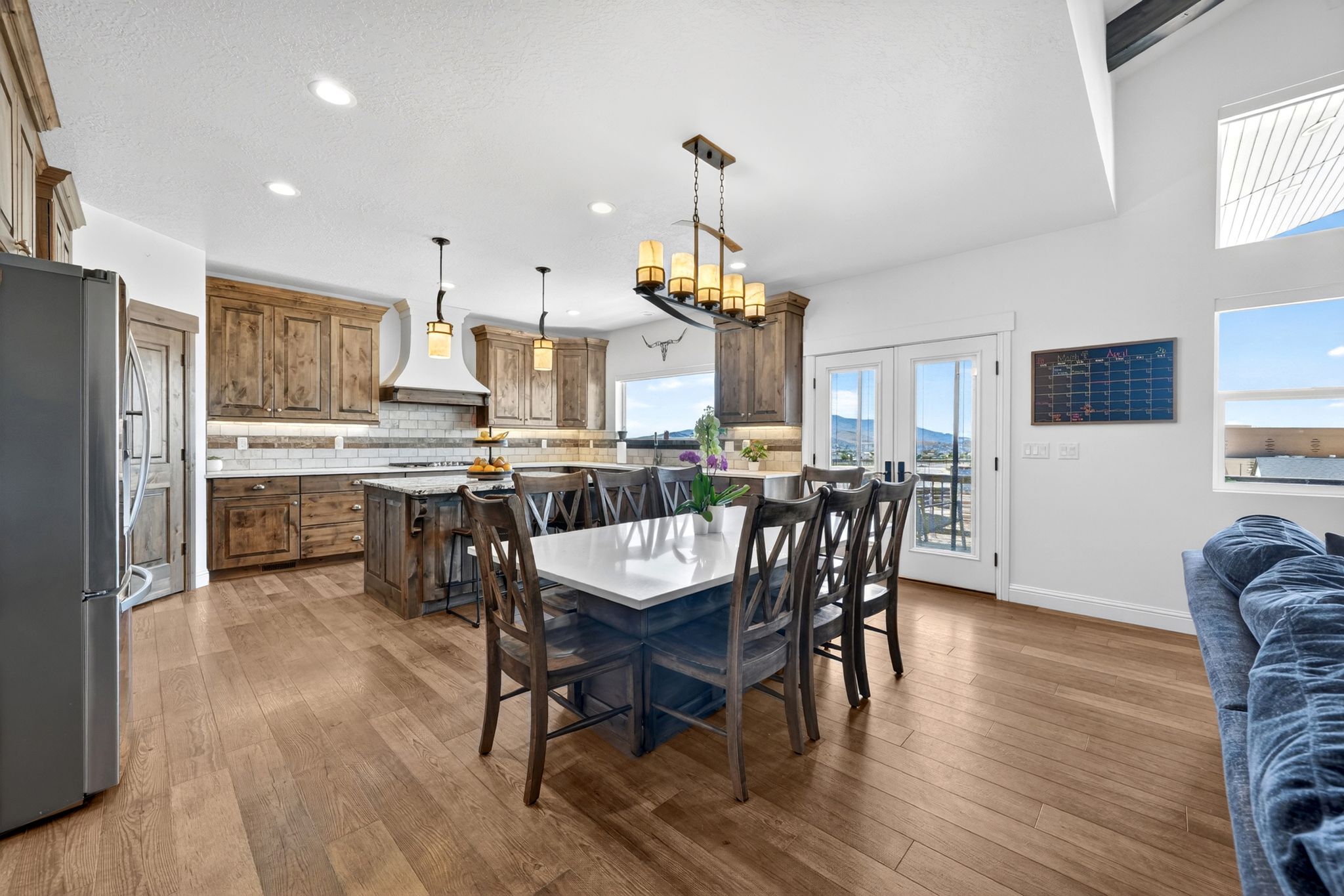 Open-concept kitchen and dining area featuring wood-finish flooring, recessed lighting, and a vaulted ceiling