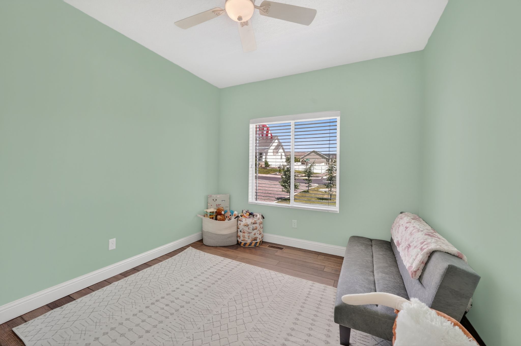 Bright room with light green walls and wood-finish flooring