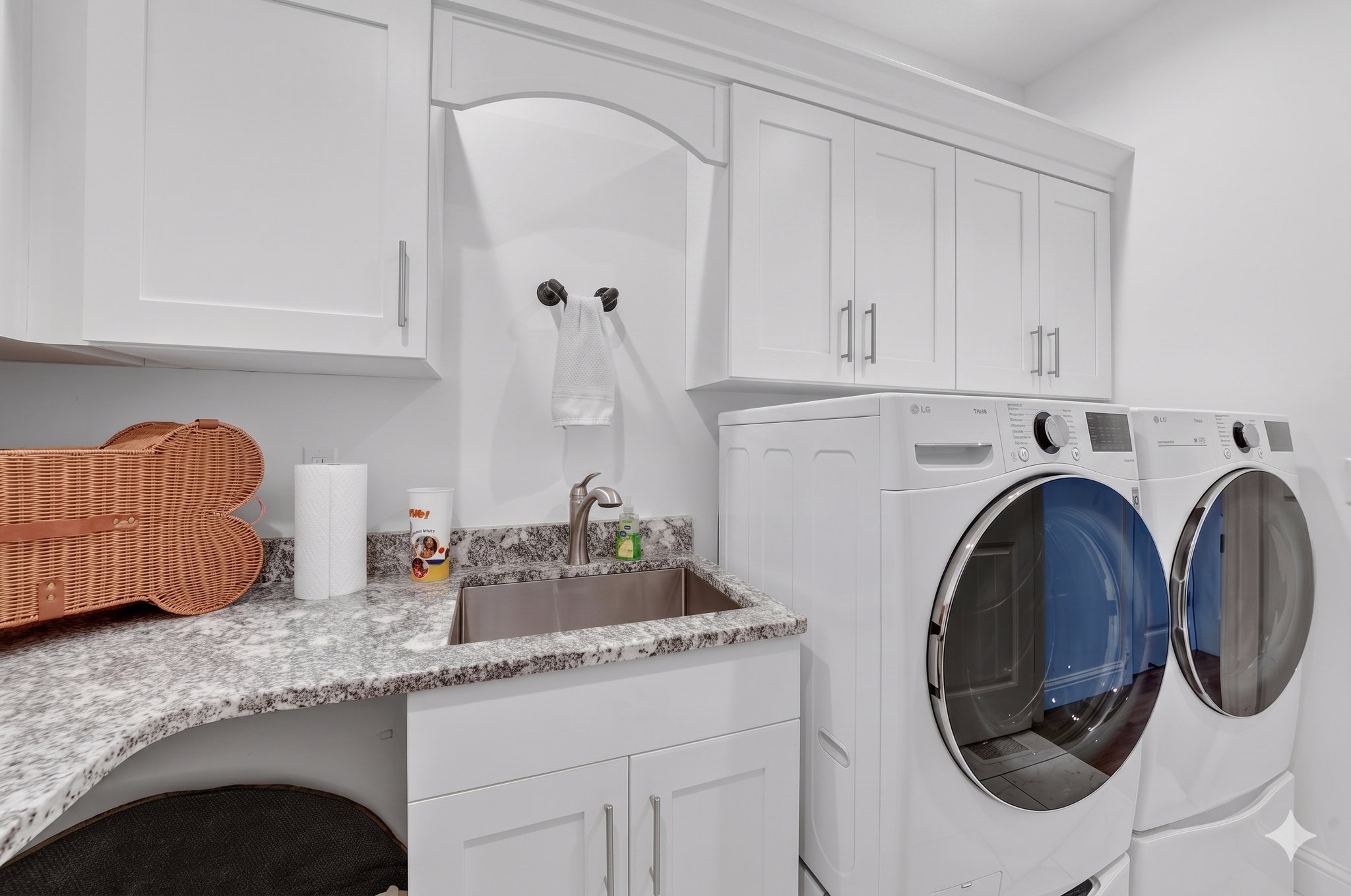 Laundry area featuring upper cabinetry, a stainless steel sink, and stone-finish countertops