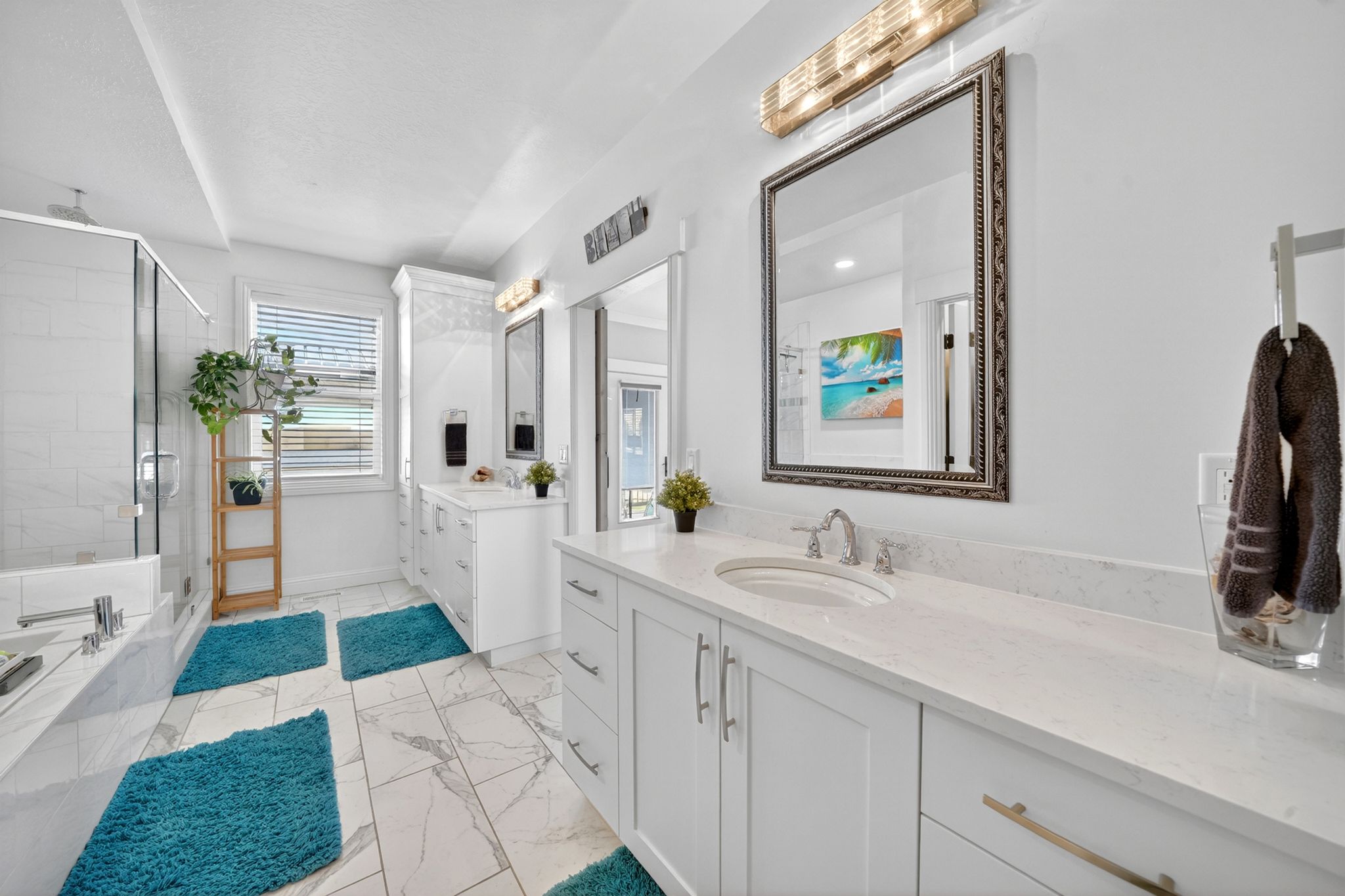 Bright bathroom featuring dual vanity with stone countertops, modern cabinetry, and individual framed mirrors