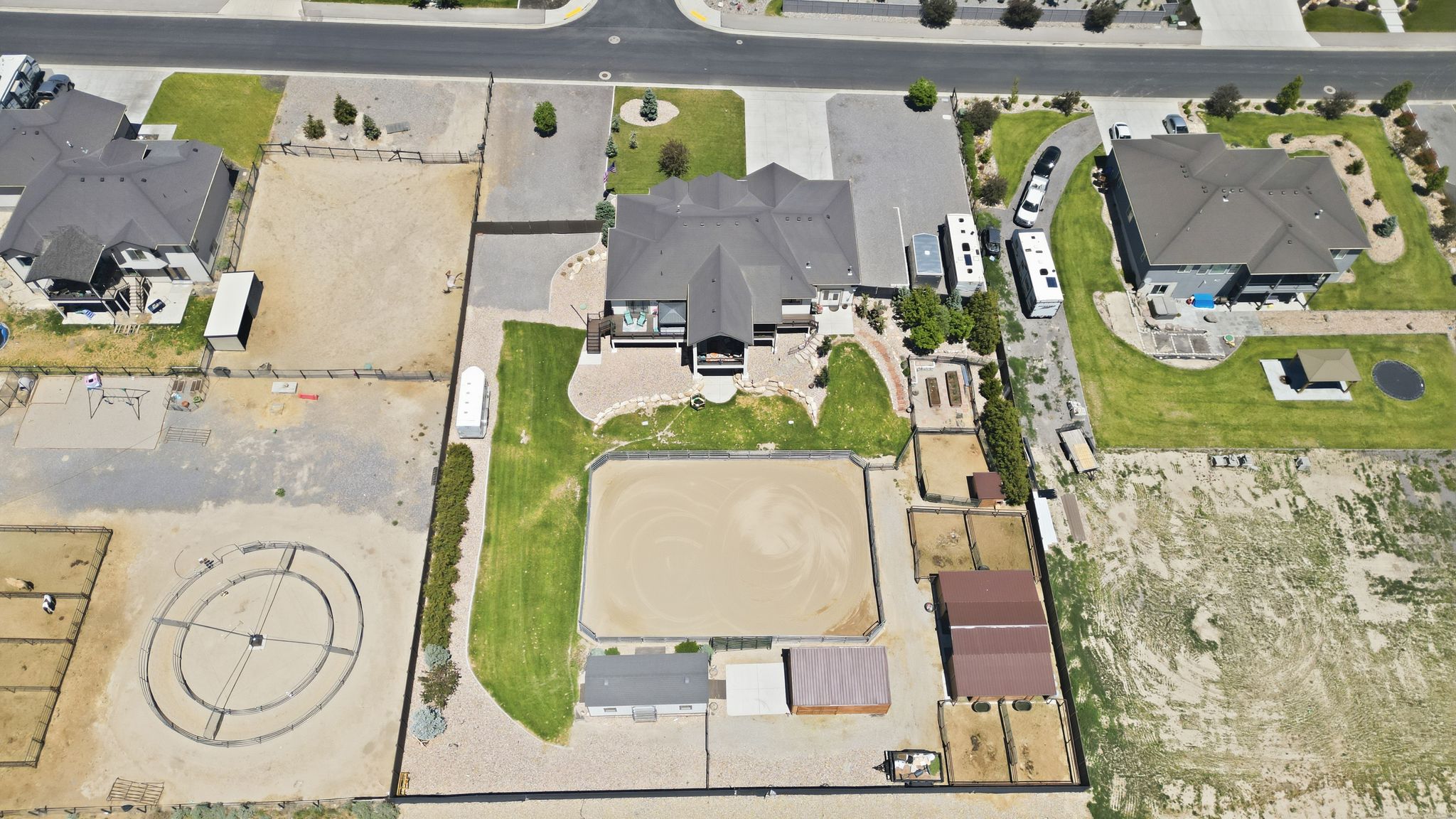 Expansive property featuring a central residence, a sizable riding arena, multiple outbuildings, and a circular training pen