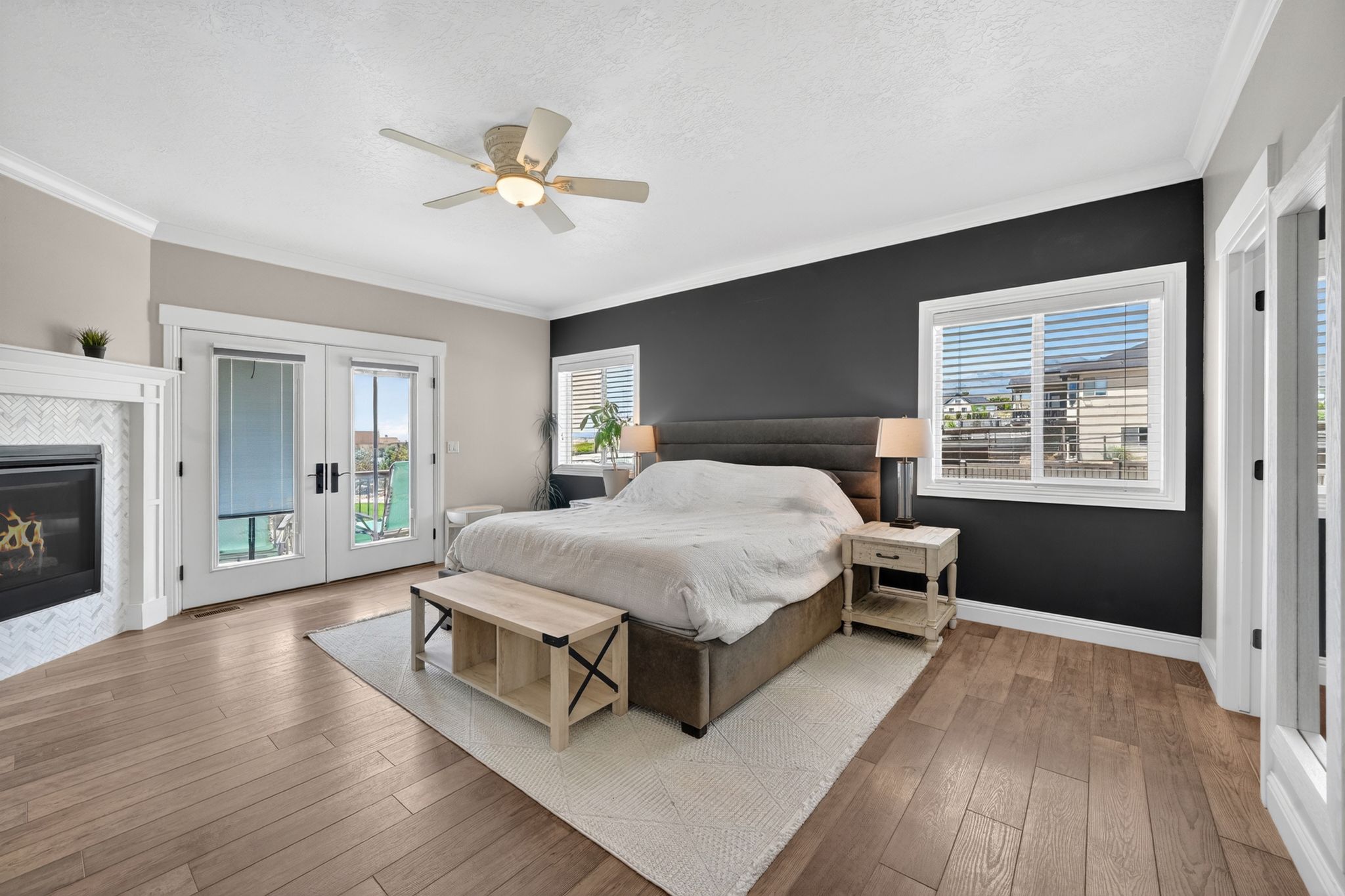 Spacious room featuring wood-finish flooring, a ceiling fan, and crown molding