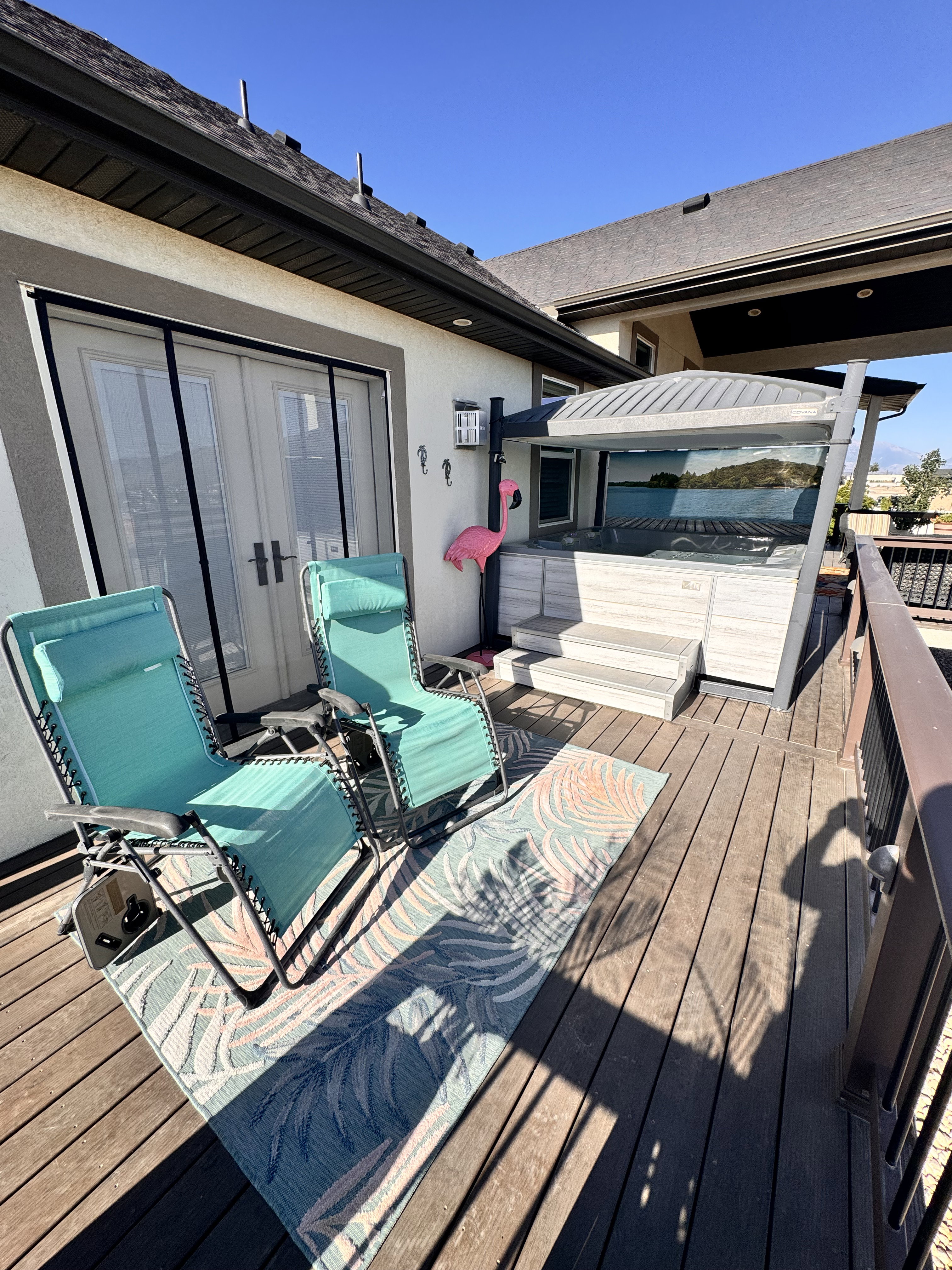 Spacious outdoor deck featuring a built-in hot tub with a protective canopy