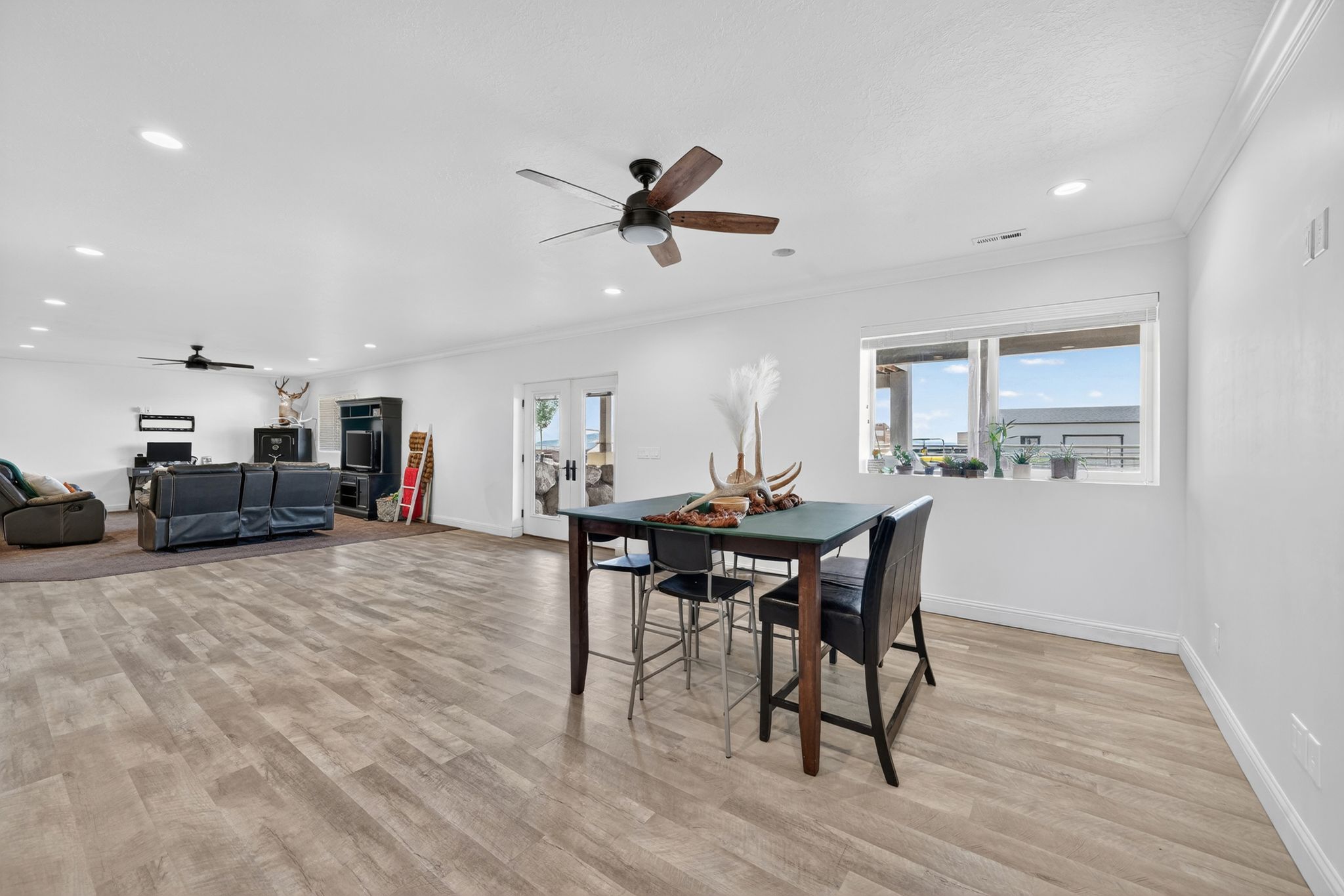 Spacious open-concept room featuring wood-finish flooring, white walls, and recessed lighting