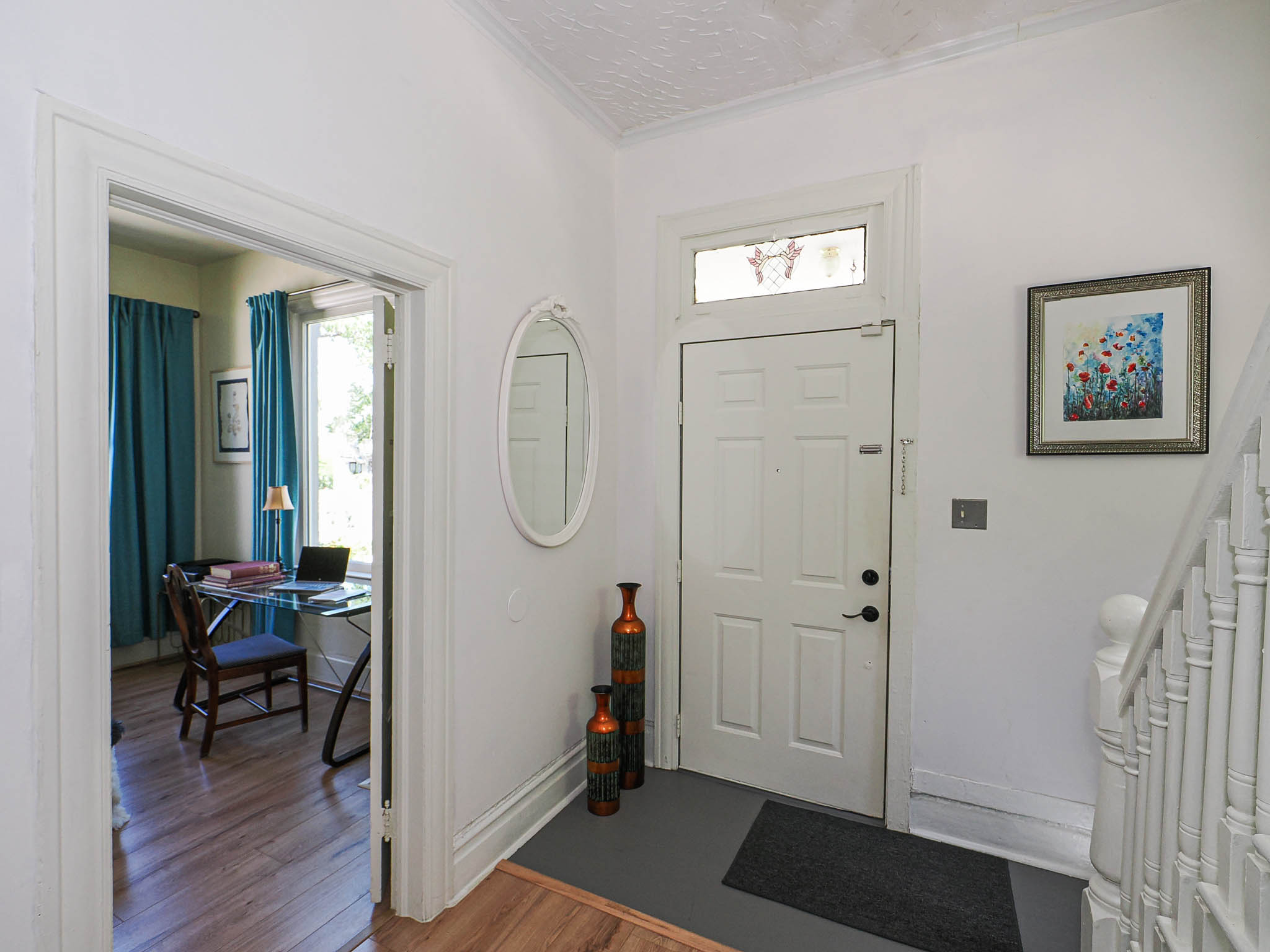 White paneled front door with transom window