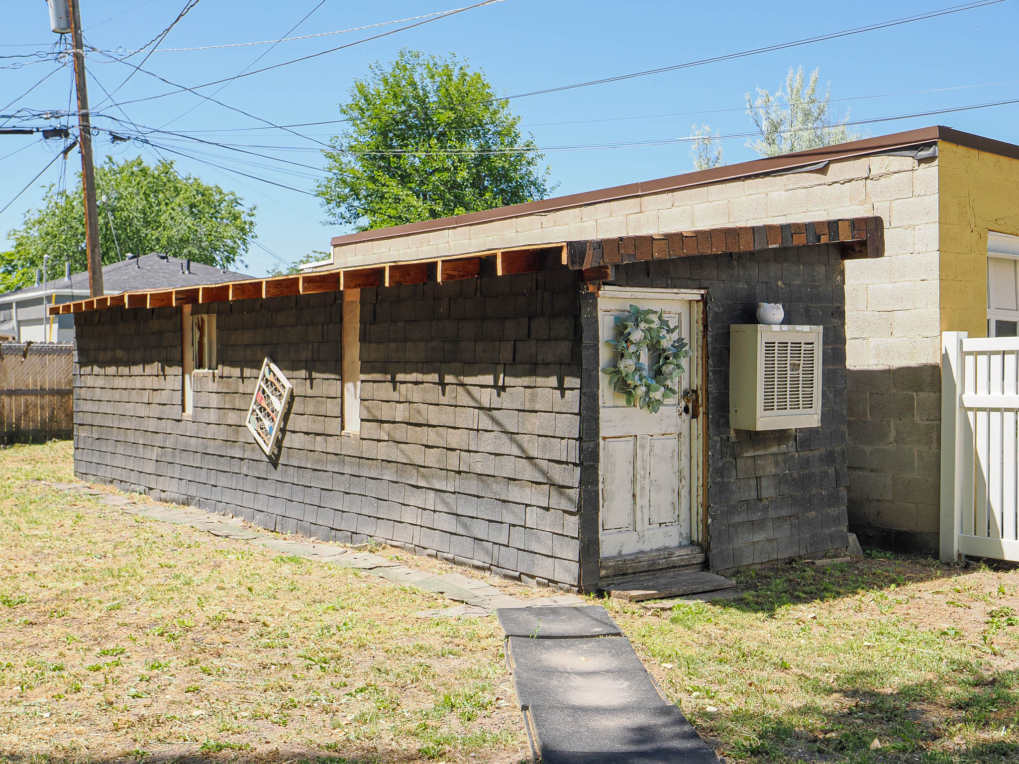 Outbuilding featuring shingle siding and a flat roofline