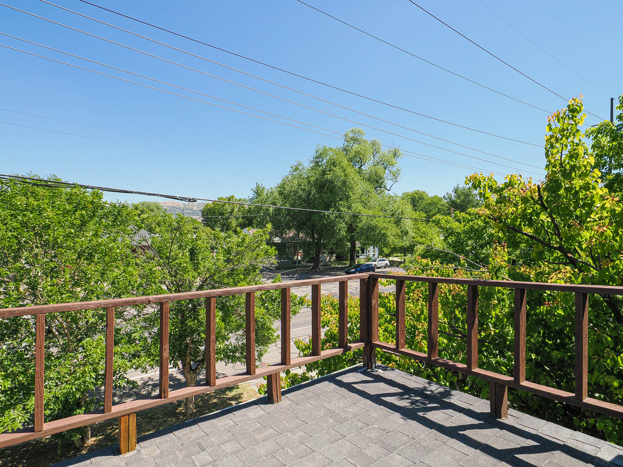 Rooftop deck featuring a wood railing and shingle surface