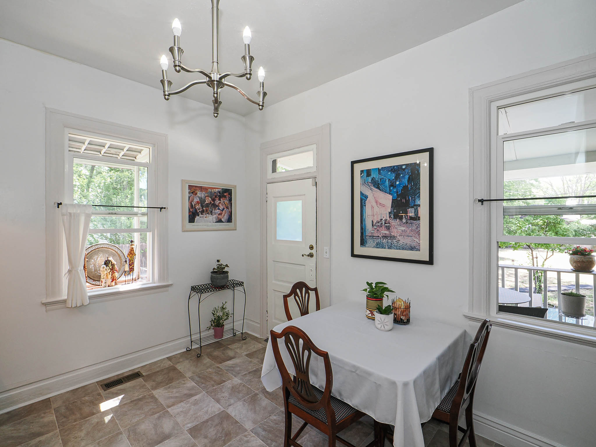 Bright dining area featuring tiled flooring and a brushed nickel chandelier