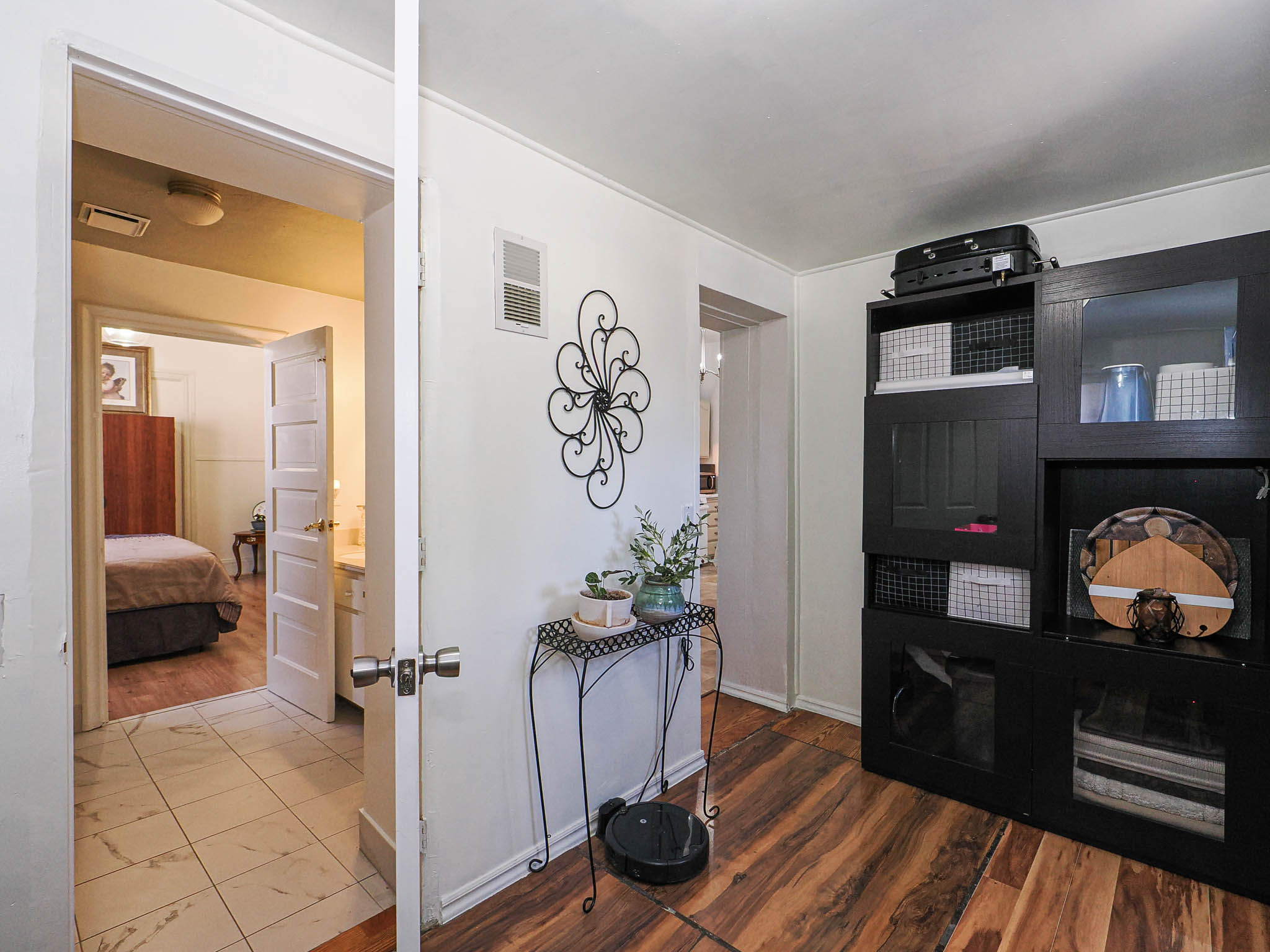 Hardwood-finish flooring extends through the main area, complemented by crisp white walls and baseboards