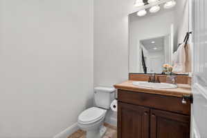 Bathroom featuring a wood vanity with a built-in sink, an extended countertop, and a wall-mounted mirror with overhead lighting