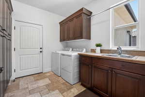 Utility room featuring a built-in sink, dark wood cabinetry, and tiled flooring