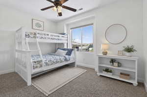 Bright room with a large window, a ceiling fan with integrated lighting, and neutral-toned carpeting