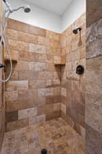 Walk-in shower with natural stone tile walls and flooring