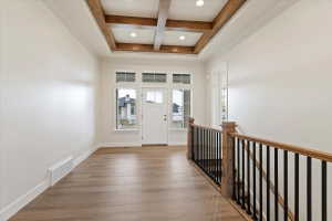 Entryway featuring a coffered ceiling with recessed lighting, LVP flooring, and a wood railing with black iron balusters