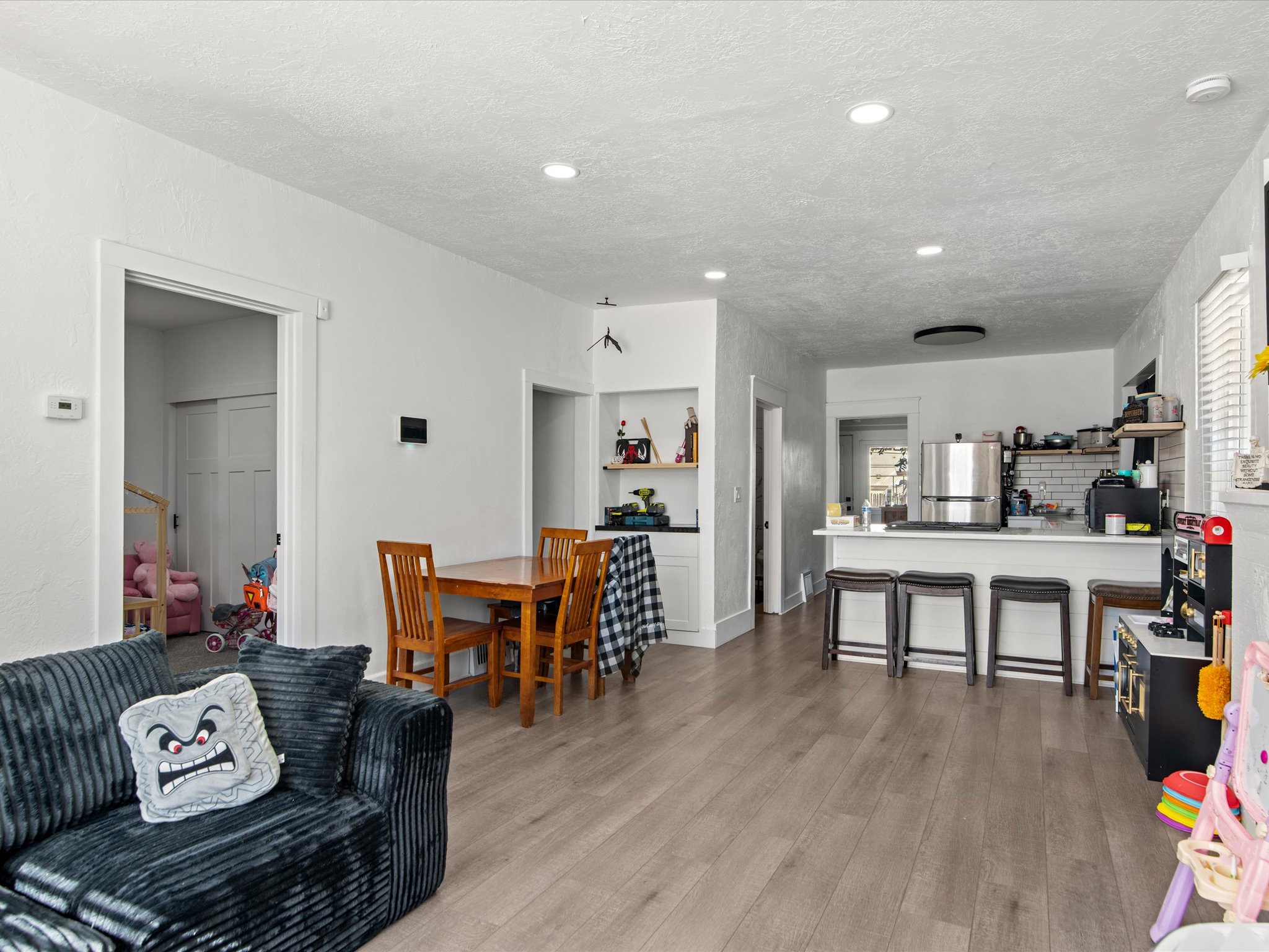 Open-concept living area featuring wood-finish flooring and recessed lighting