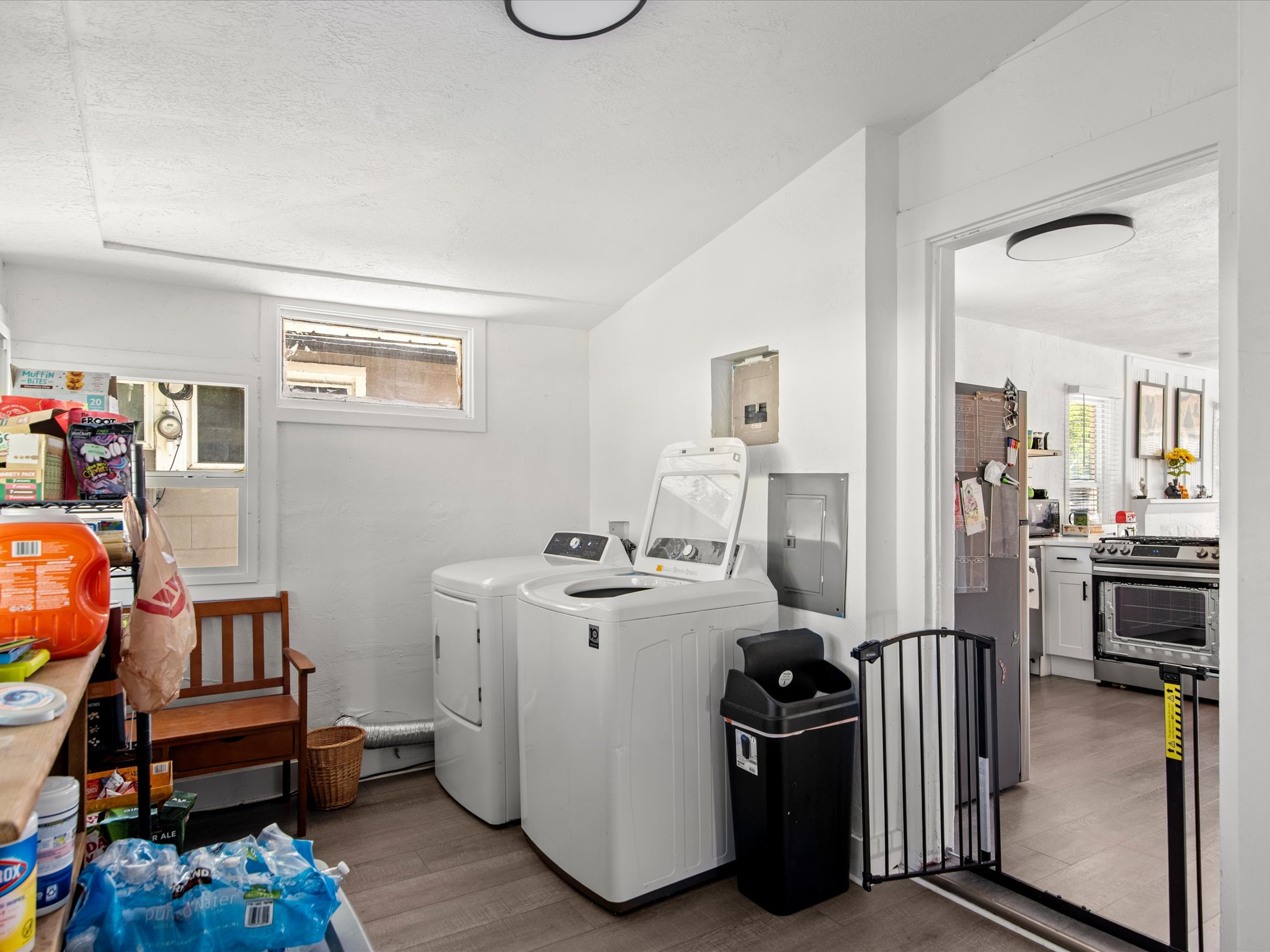 Dedicated laundry area featuring a washer and dryer, wood-finish flooring, and multiple windows