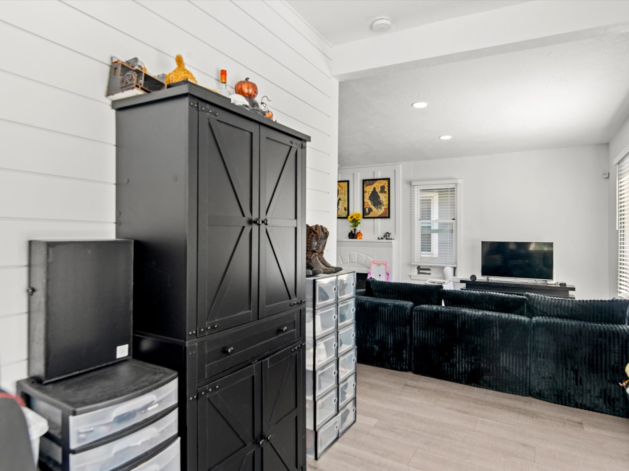 Light wood-finish flooring extending into a bright room with white walls