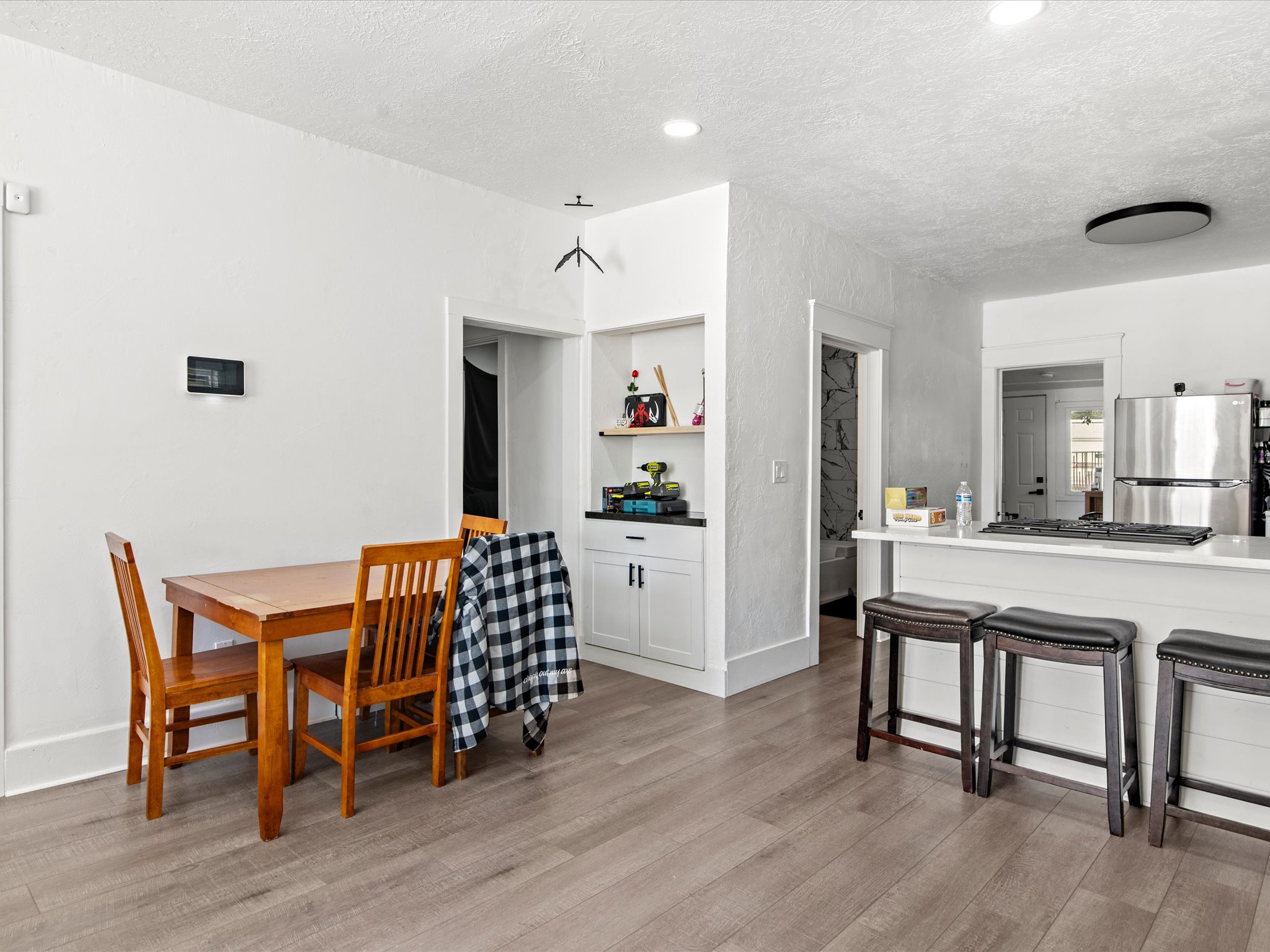 Open-concept living space featuring wood-finish flooring, white walls, and recessed lighting