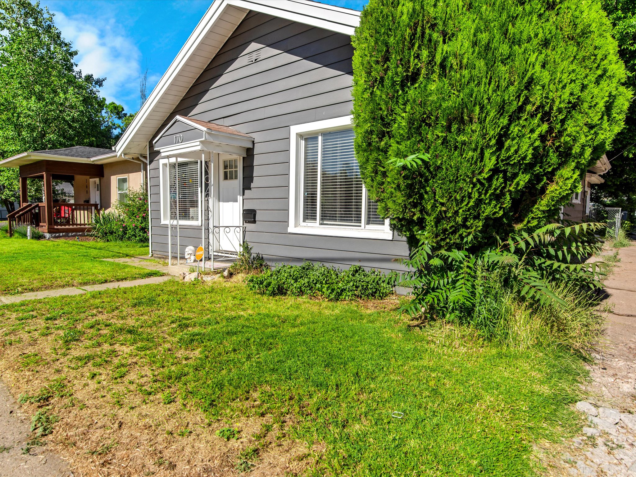 Gray exterior siding with white trim and a covered front entry