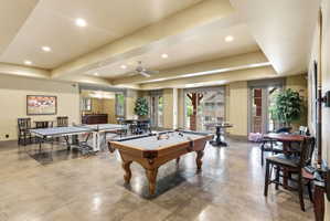 Spacious entertainment room featuring concrete flooring, recessed lighting, and a ceiling fan