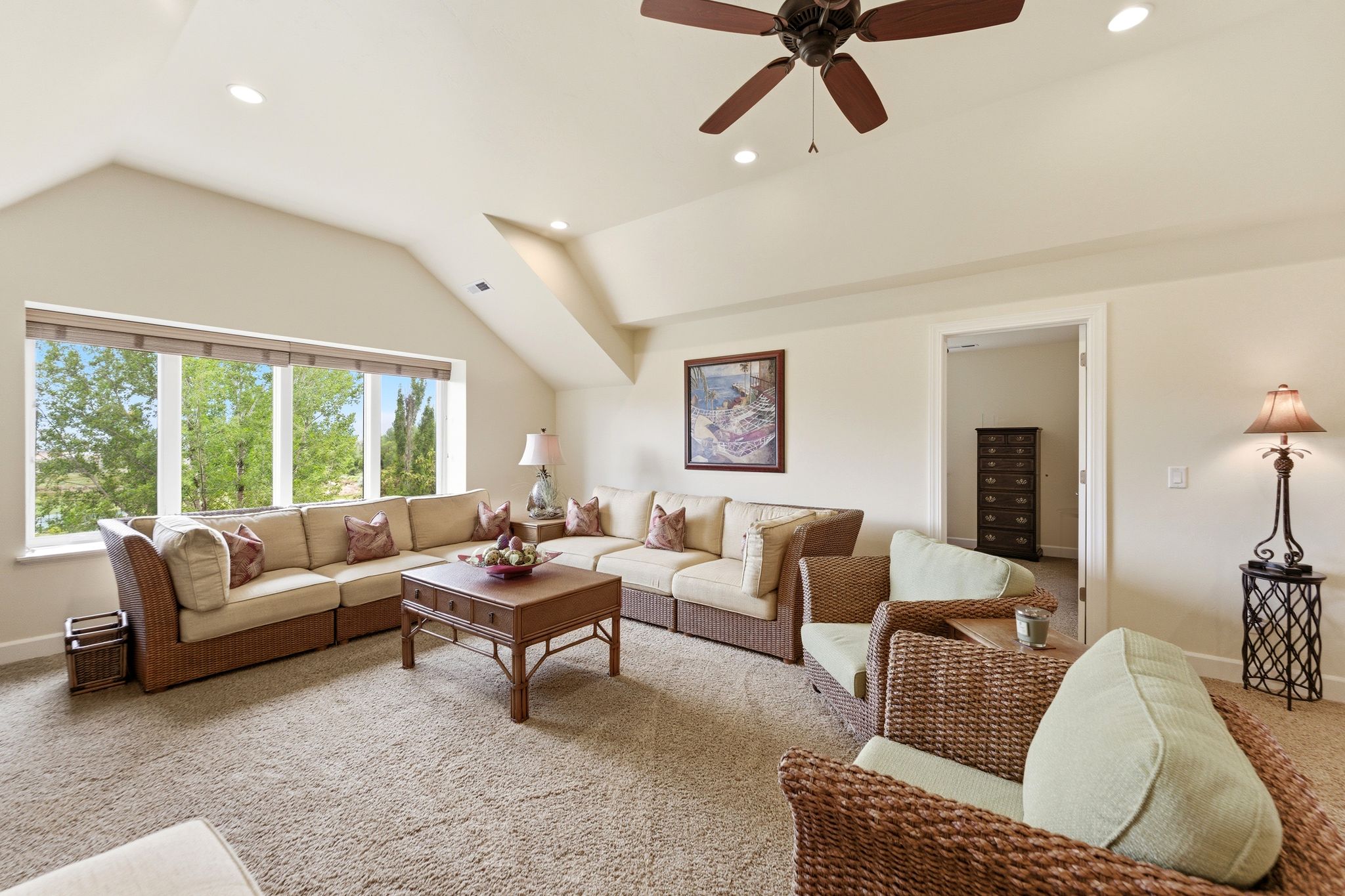 Spacious bonus room featuring a wide window, sloped ceilings, recessed lighting, a ceiling fan, and carpet flooring