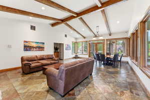 2nd clubhouse Open-concept room featuring vaulted ceilings with exposed wood beams, recessed lighting, and large multi-pane windows with wood frames