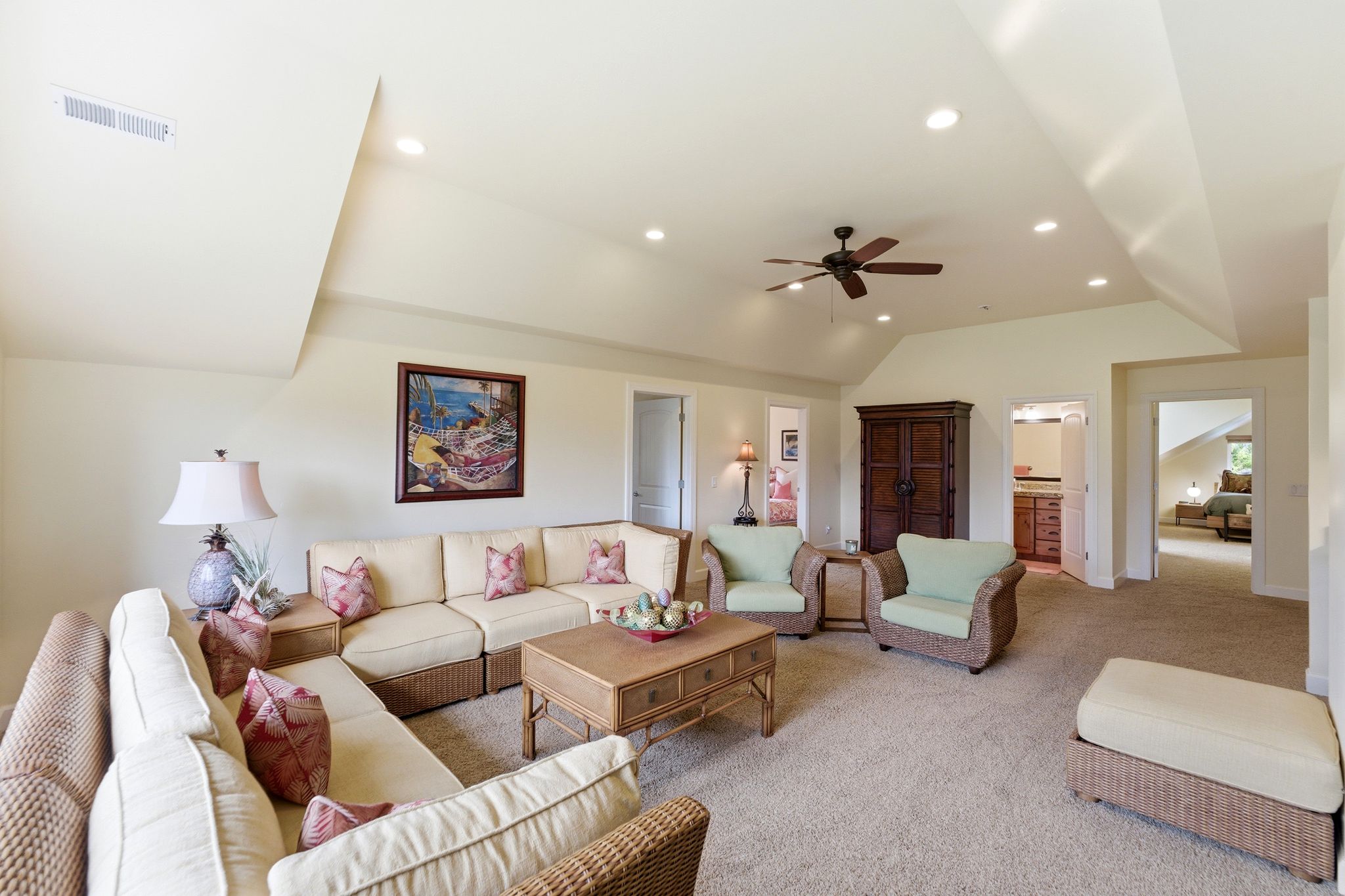 Spacious living area featuring vaulted ceilings, recessed lighting, ceiling fan, and carpet flooring