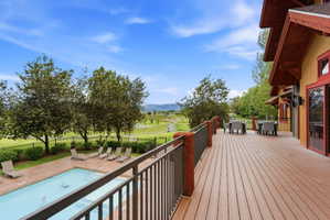 Expansive outdoor deck featuring wood-finish flooring and a metal railing