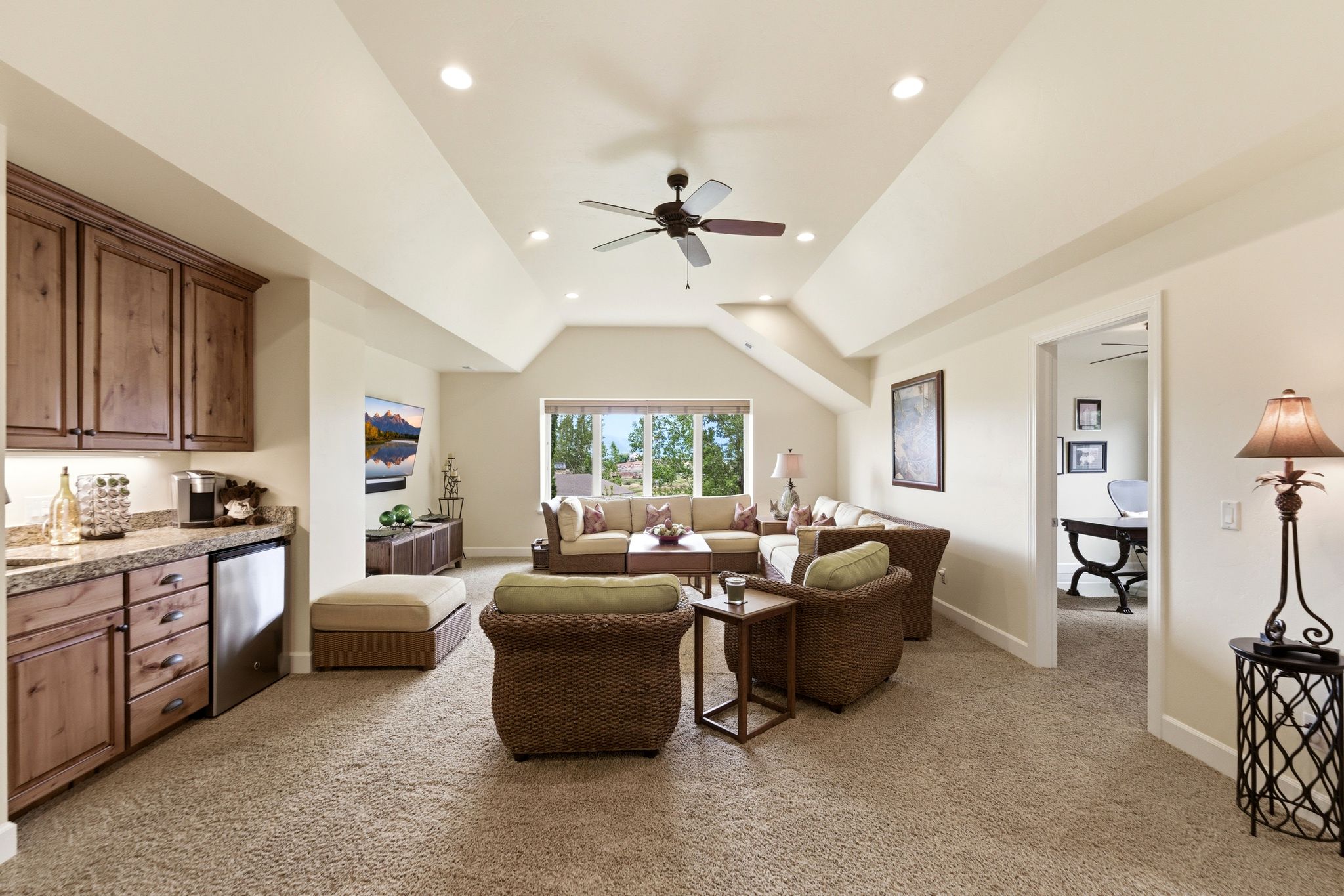 Spacious room featuring vaulted ceilings, recessed lighting, and a ceiling fan