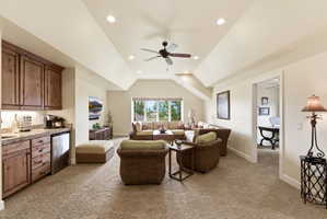 Spacious room featuring vaulted ceilings, recessed lighting, and a ceiling fan