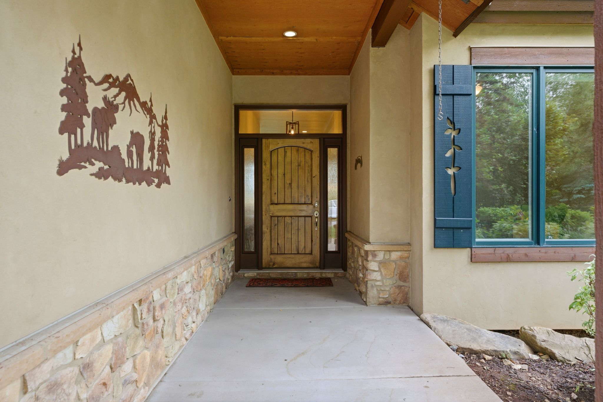 Inviting entry with a solid wood door flanked by sidelight windows and a transom