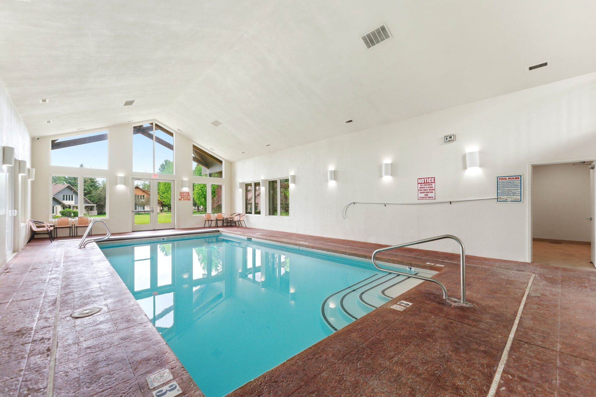 Indoor swimming pool with an expansive vaulted ceiling and large glass panels