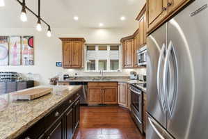 Kitchen featuring wood-finish flooring, recessed lighting, and a kitchen island with a granite countertop