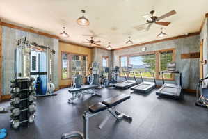 Dedicated fitness space featuring rubber flooring, corrugated metal wall accents, exposed wood trim, and multiple windows