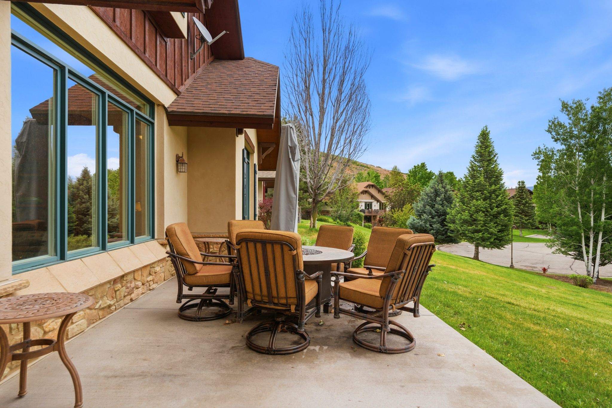 Expansive concrete patio area with a stone base and stucco exterior