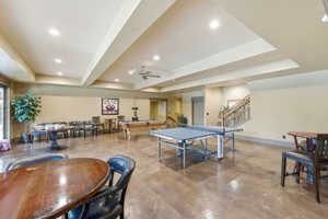 Spacious recreation room featuring concrete flooring, recessed lighting, and a ceiling fan