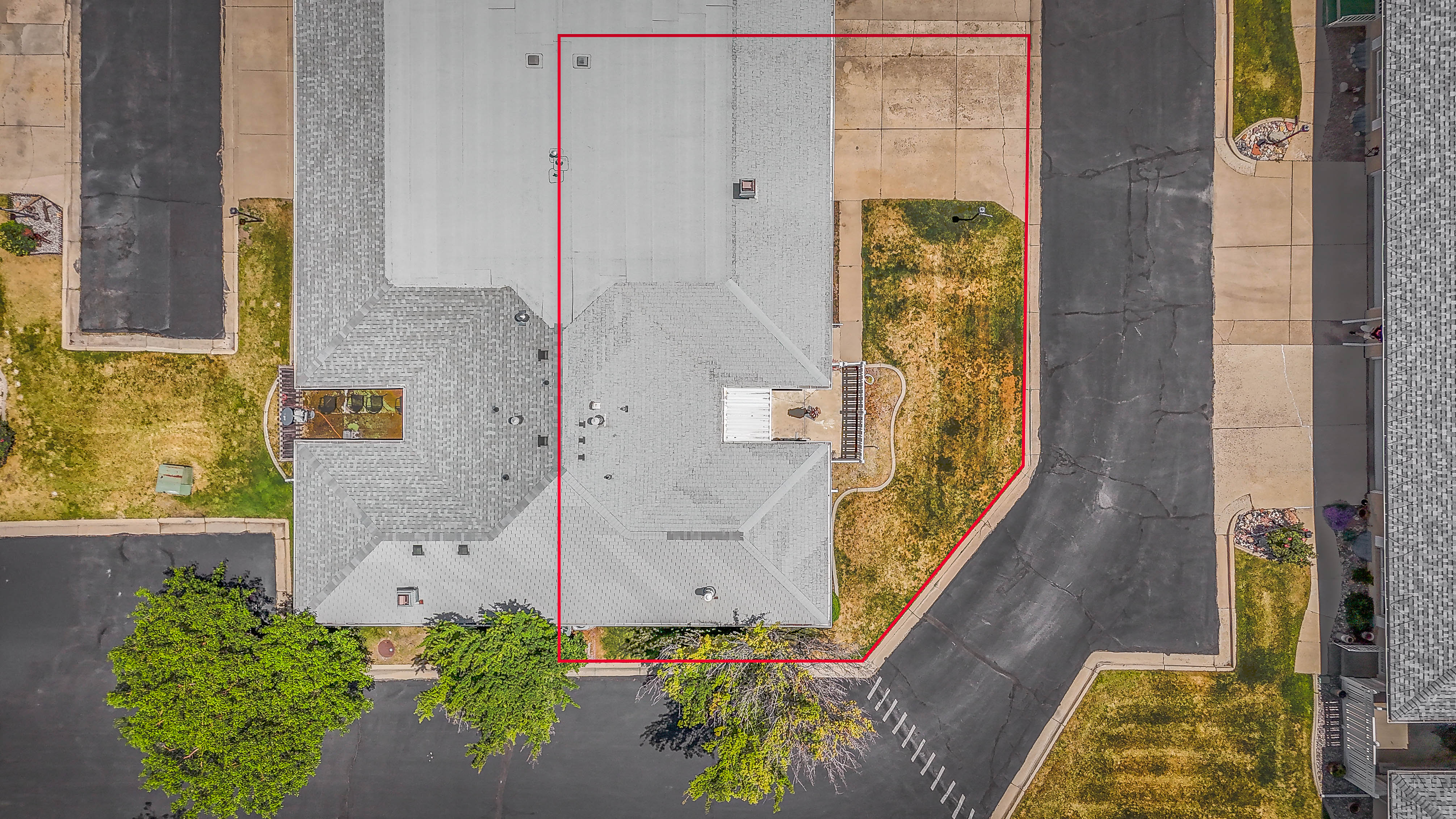 Aerial perspective showcasing the property's footprint with a gray shingle roof and a concrete driveway