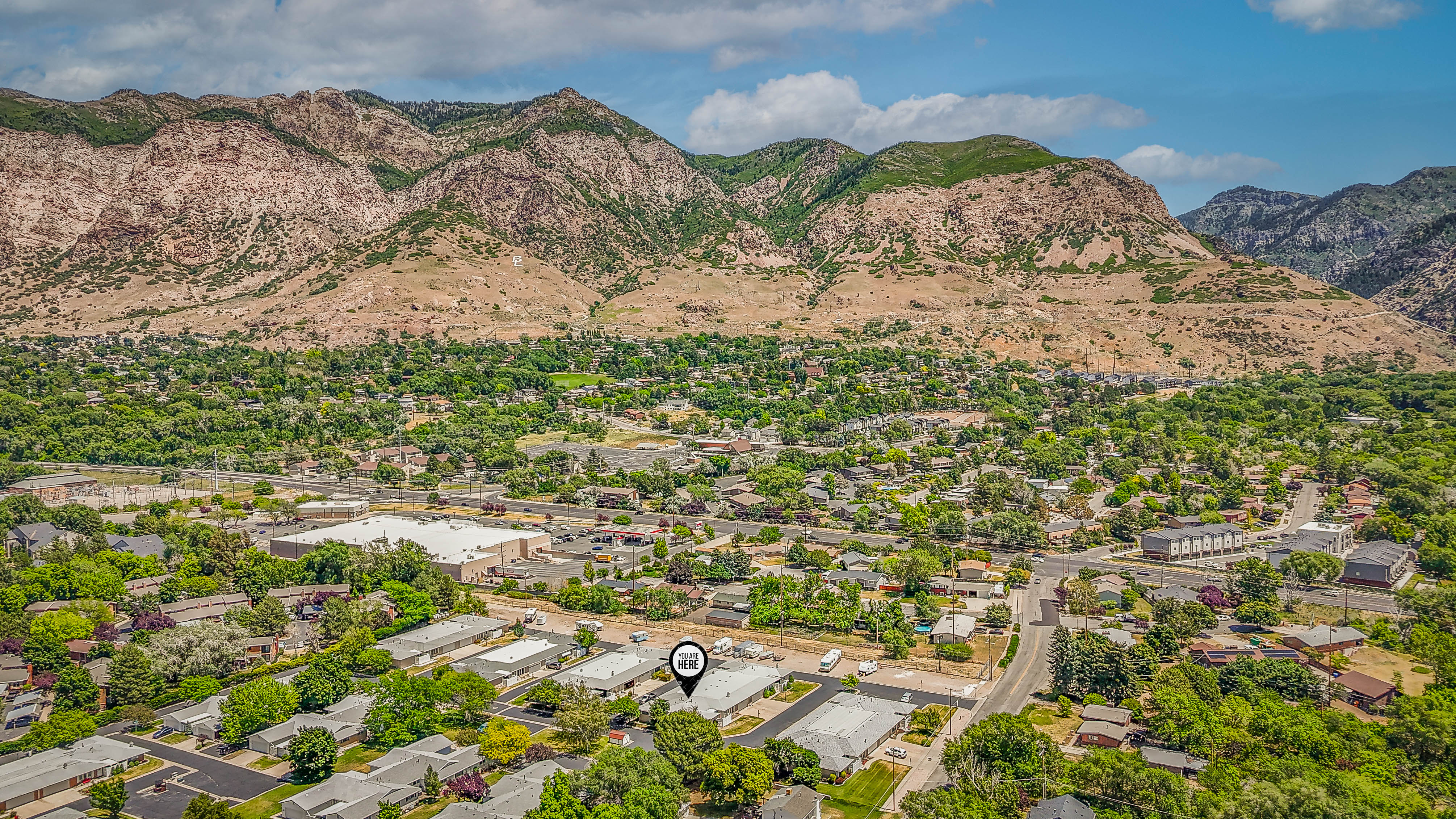 Aerial perspective showcasing a residential and commercial area with prominent mountain backdrops