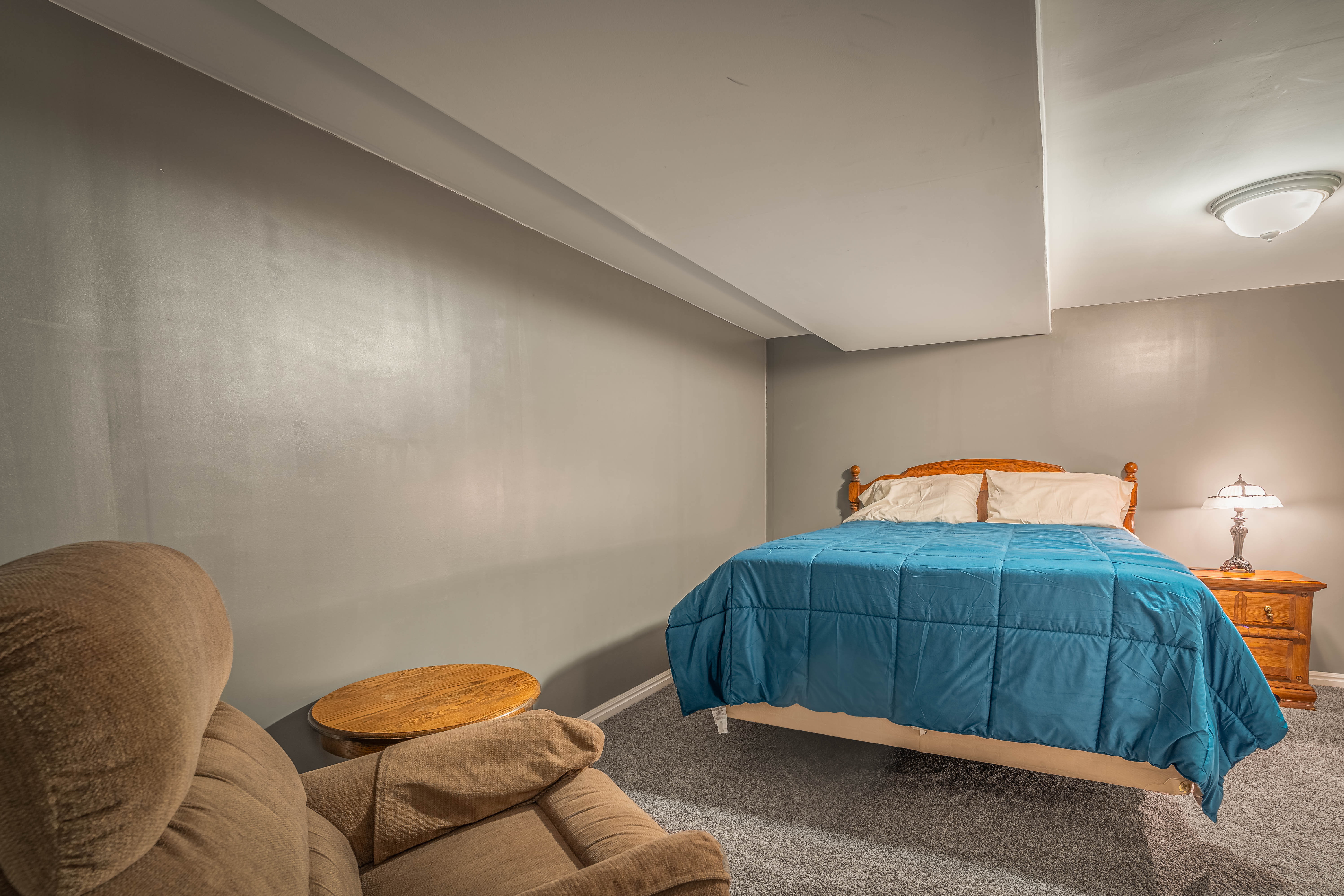 Carpeted room featuring a ceiling-mounted light fixture, recessed ceiling elements, and neutral wall tones