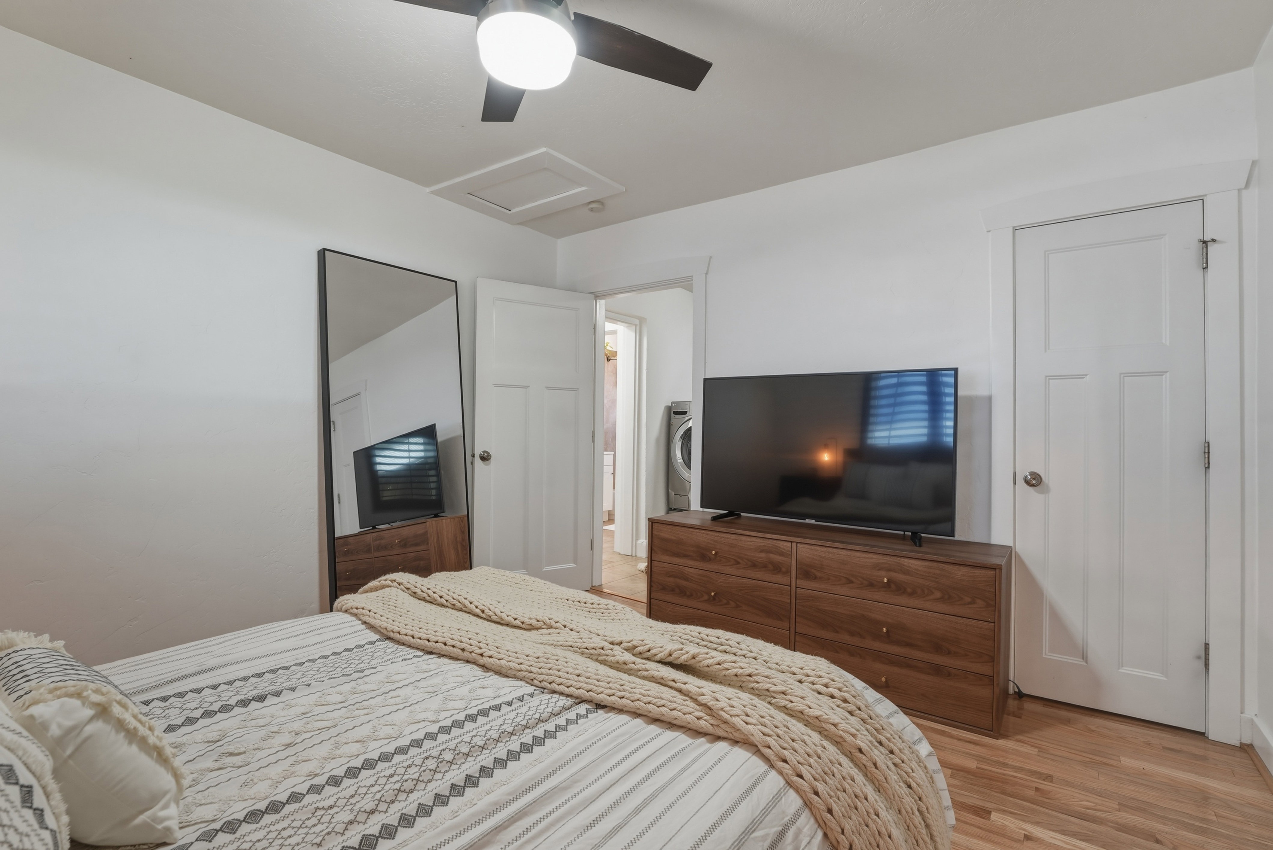 Bright room featuring wood-finish flooring and a ceiling fan with integrated lighting