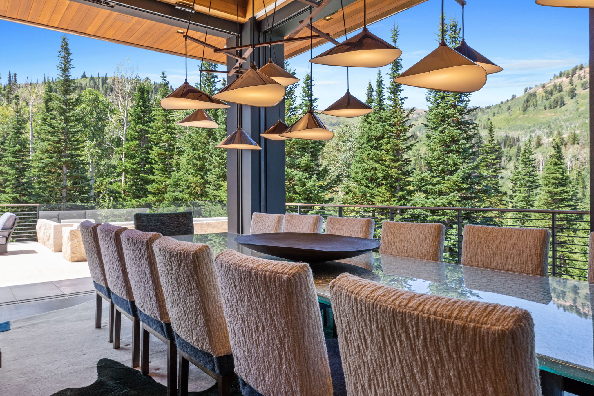 Dining area featuring a large rectangular table, upholstered chairs, and multiple pendant light fixtures